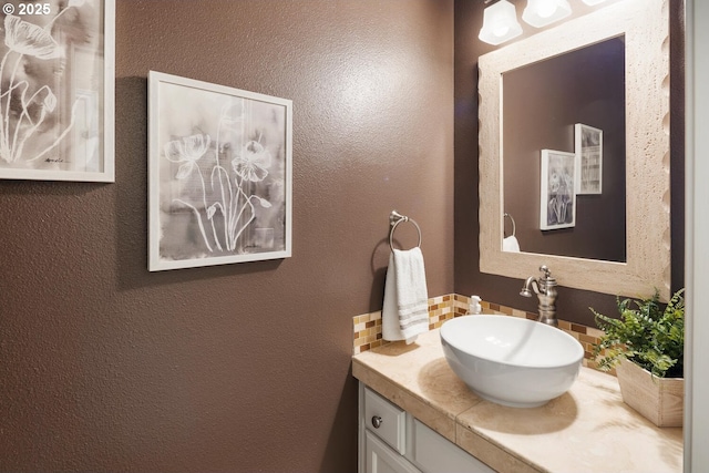 bathroom featuring backsplash, vanity, and a textured wall
