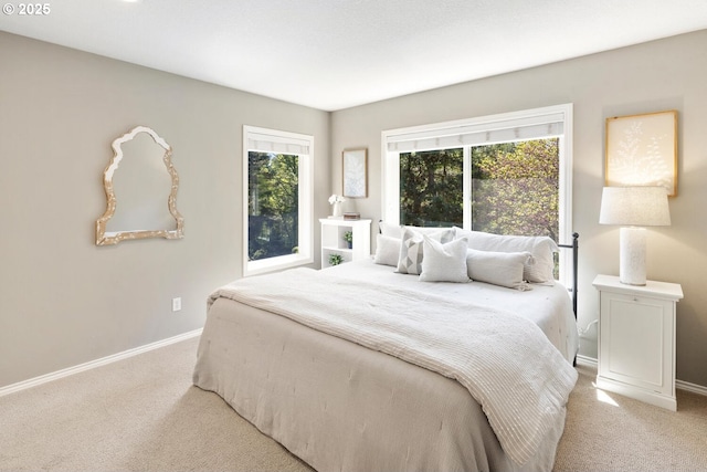 bedroom featuring light colored carpet and baseboards