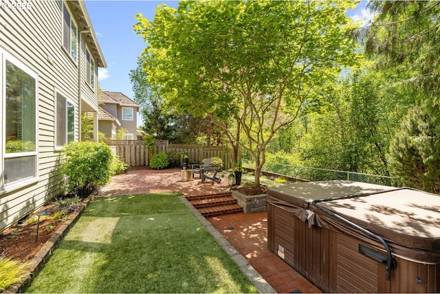 view of yard with a hot tub and a patio area