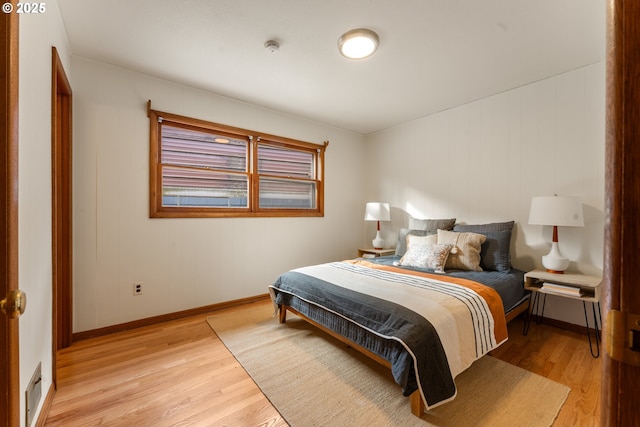 bedroom with light wood-type flooring, visible vents, and baseboards