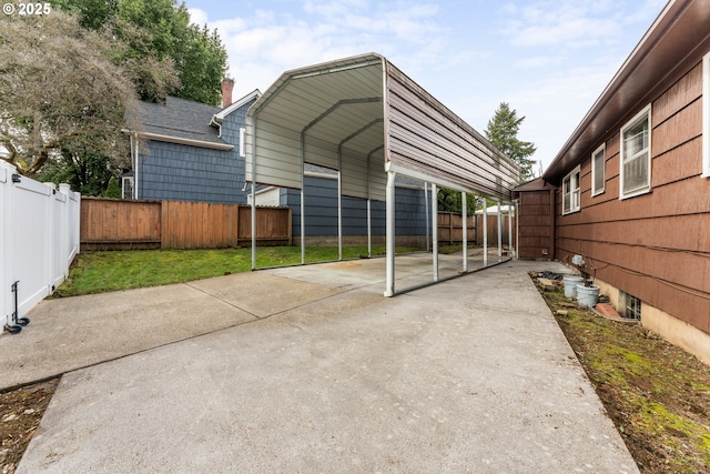 exterior space featuring a carport, driveway, and fence