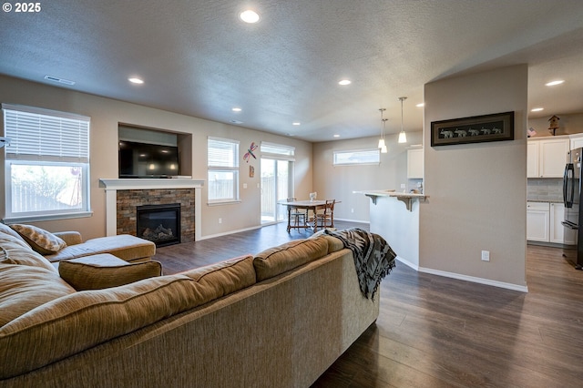 1531 Washington St, Independence, OR 97351 - living room featuring baseboards, dark wood finished floors, a stone fireplace, recessed lighting, and a textured ceiling
