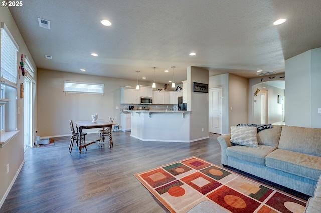 1531 Washington St, Independence, OR 97351 - living room featuring dark wood-style flooring, recessed lighting, arched walkways, and baseboards