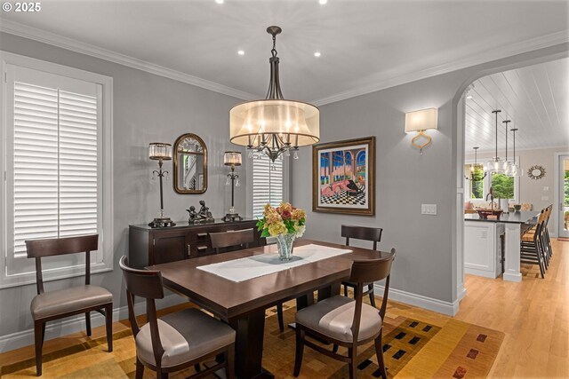 330 6th St, Lake Oswego, OR 97034 - dining area featuring baseboards, light wood-style floors, a chandelier, ornamental molding, and arched walkways