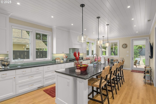 kitchen featuring wood ceiling, light wood-style flooring, white cabinets, a sink, and recessed lighting