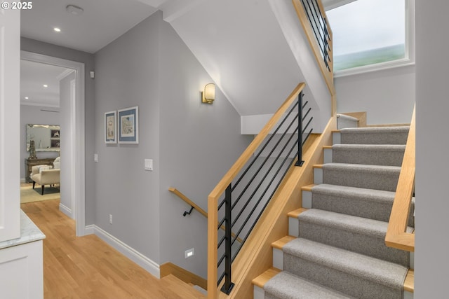 stairway with wood finished floors, recessed lighting, and baseboards