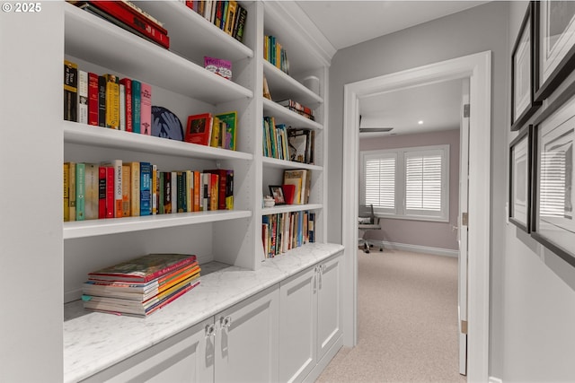 hall with light colored carpet and baseboards
