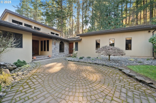 rear view of property featuring stone siding