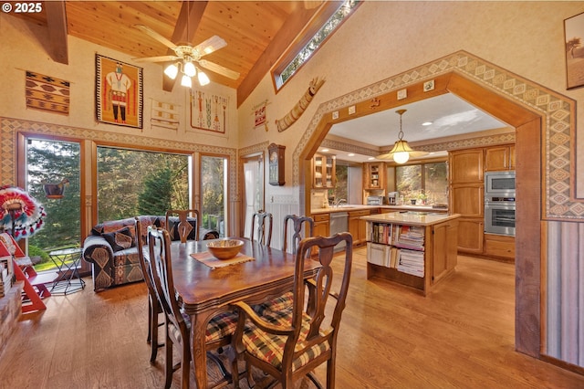 dining area featuring ceiling fan, light wood-style flooring, wood ceiling, and high vaulted ceiling