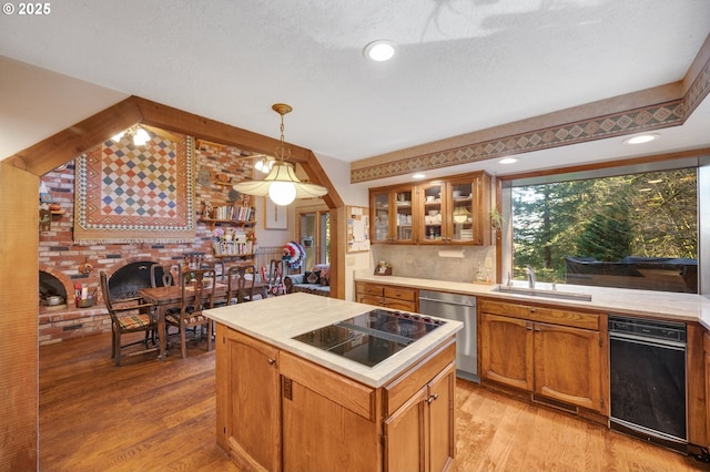 kitchen with light wood-style flooring, dishwasher, black electric cooktop, and a sink