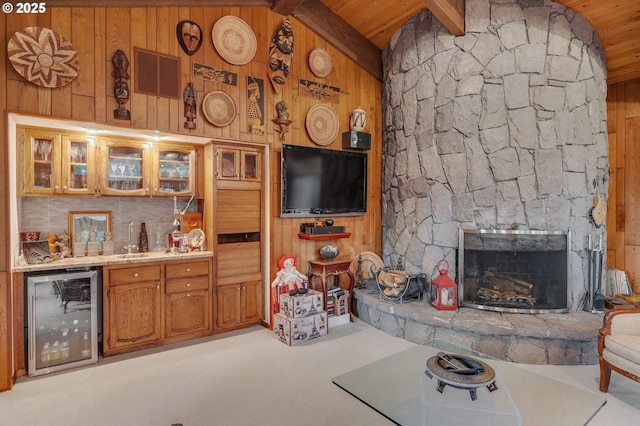 unfurnished living room featuring visible vents, wooden walls, vaulted ceiling with beams, wine cooler, and a bar