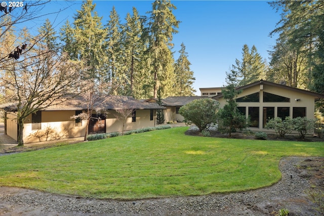 exterior space with stucco siding and a lawn