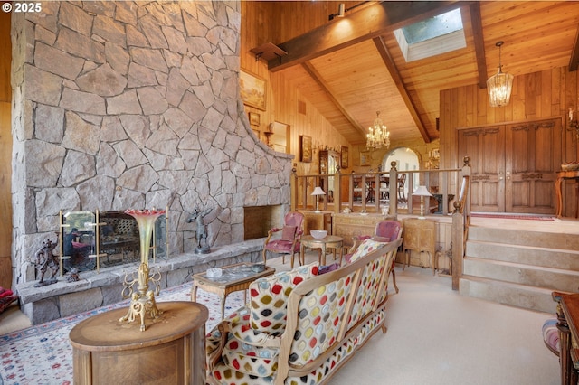 living room with beam ceiling, a fireplace, a skylight, wooden ceiling, and an inviting chandelier