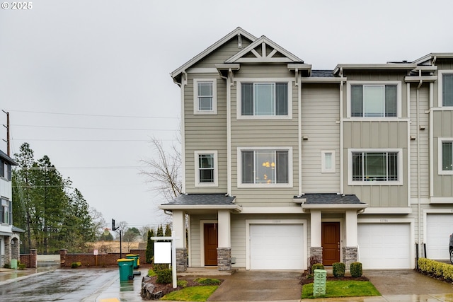 townhome / multi-family property with roof with shingles, concrete driveway, a garage, stone siding, and board and batten siding