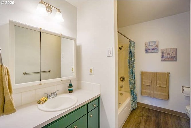 full bath with toilet, shower / bath combo, wood finished floors, and vanity