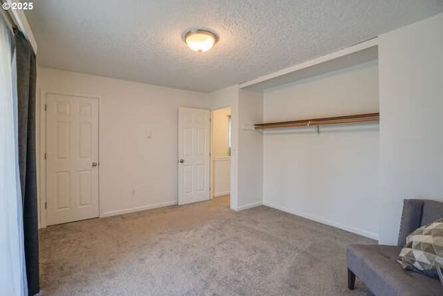 unfurnished bedroom with carpet, baseboards, a closet, and a textured ceiling