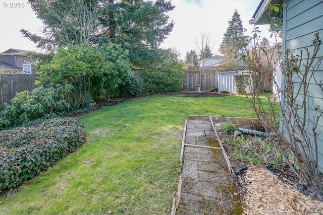 view of yard featuring a fenced backyard and a garden