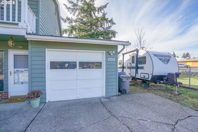 garage with driveway and fence