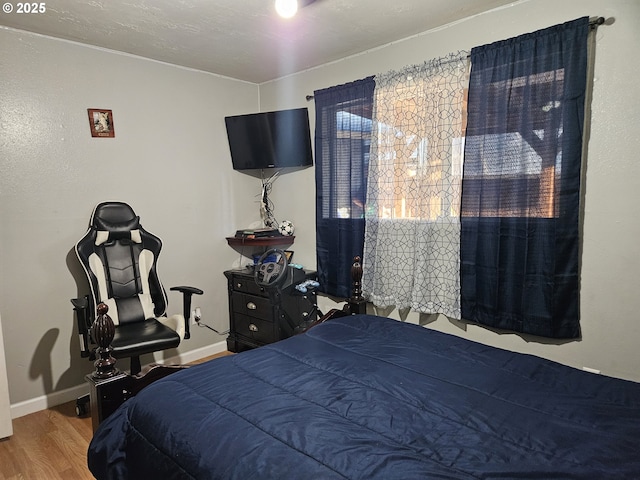 bedroom with wood finished floors and baseboards