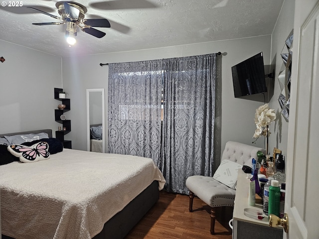 bedroom with dark wood-style flooring, ceiling fan, and a textured ceiling