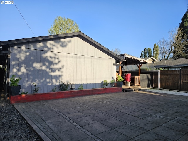 view of side of home featuring a gazebo, a patio, and fence