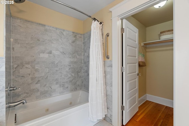 full bath featuring shower / tub combo, wood finished floors, and baseboards