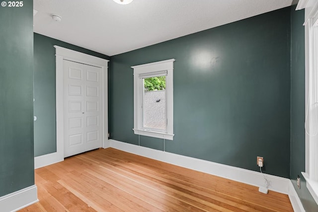 unfurnished bedroom with light wood-type flooring and baseboards