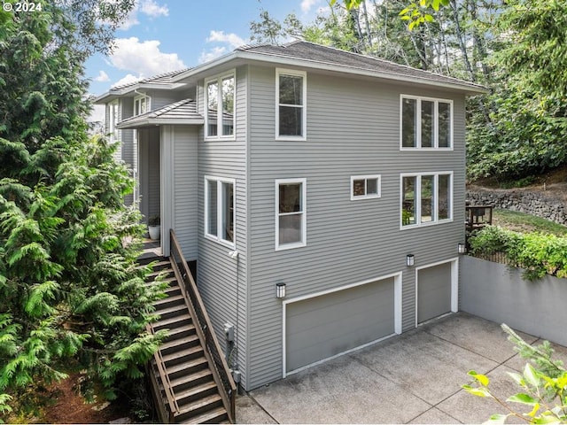 8427 NW Timber Ridge Ct, Portland, OR 97229 - view of home's exterior featuring stairs, an attached garage, and driveway