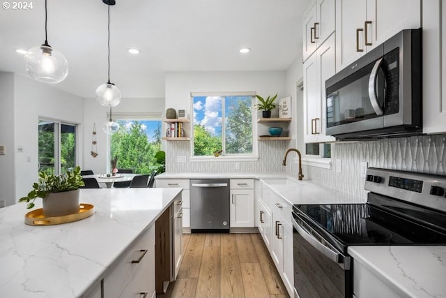 8427 NW Timber Ridge Ct, Portland, OR 97229 - kitchen with appliances with stainless steel finishes, open shelves, white cabinetry, light wood finished floors, and recessed lighting