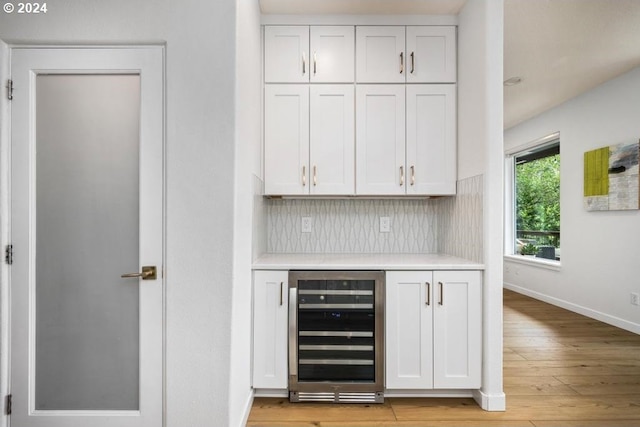 8427 NW Timber Ridge Ct, Portland, OR 97229 - indoor dry bar featuring wine cooler, tasteful backsplash, baseboards, and light wood finished floors