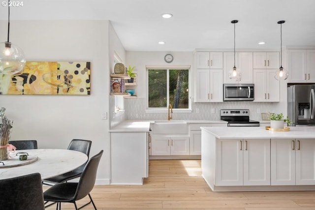 8427 NW Timber Ridge Ct, Portland, OR 97229 - kitchen with appliances with stainless steel finishes, a sink, light countertops, white cabinetry, and recessed lighting