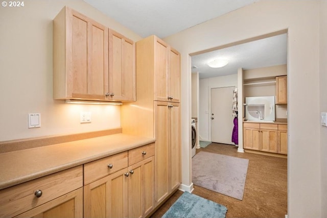 8427 NW Timber Ridge Ct, Portland, OR 97229 - kitchen featuring light brown cabinets, light countertops, washer / clothes dryer, and dark carpet
