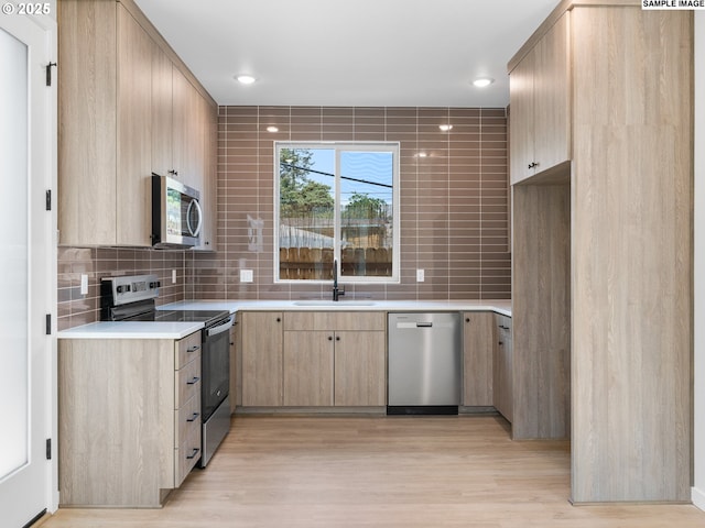 4043 SE 115th Ave, Portland, OR 97266 - kitchen with stainless steel appliances, light brown cabinets, backsplash, light countertops, and a sink