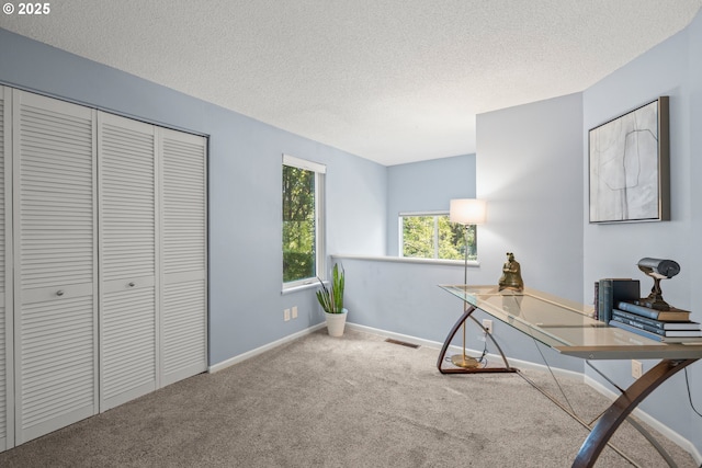 office with carpet flooring, a textured ceiling, visible vents, and baseboards