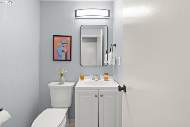 half bathroom featuring vanity and toilet