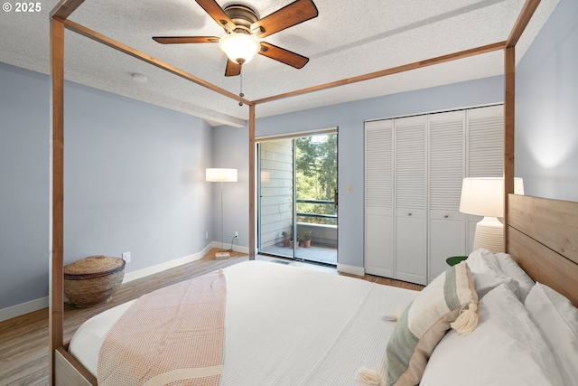 bedroom featuring baseboards, a ceiling fan, a textured ceiling, and wood finished floors
