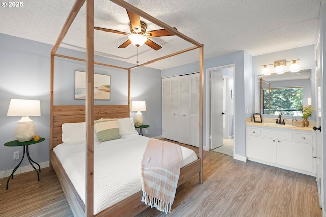 bedroom featuring a sink, light wood-type flooring, and a textured ceiling