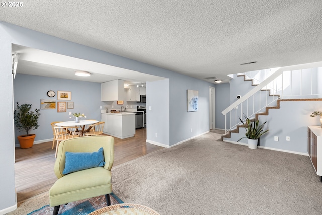 interior space with stairs, a textured ceiling, light carpet, and baseboards