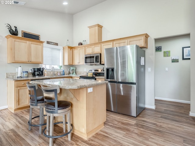 3190 Lily Ln, Mcminnville, OR 97128 - kitchen featuring appliances with stainless steel finishes, light brown cabinetry, high vaulted ceiling, a sink, and recessed lighting