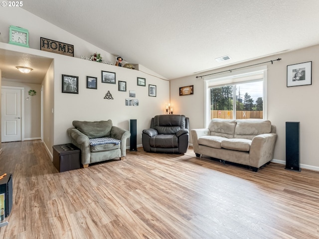3190 Lily Ln, Mcminnville, OR 97128 - living room featuring lofted ceiling, light wood-type flooring, a textured ceiling, and baseboards