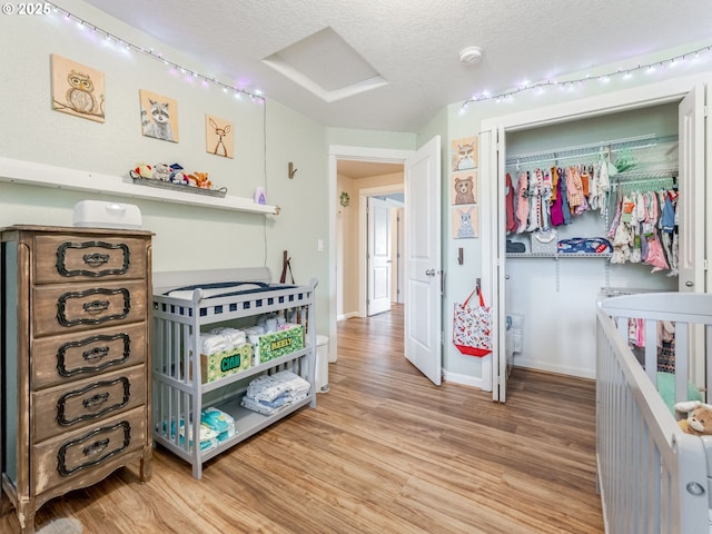 3190 Lily Ln, Mcminnville, OR 97128 - bedroom featuring attic access, light wood-style floors, track lighting, a textured ceiling, and a closet