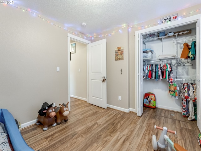3190 Lily Ln, Mcminnville, OR 97128 - bedroom featuring wood finished floors, a closet, a textured ceiling, and baseboards