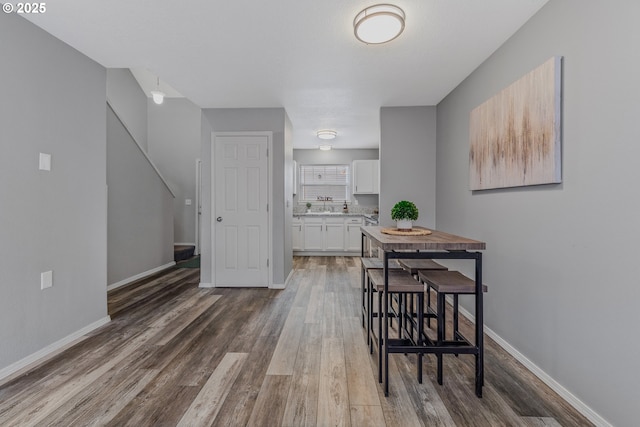 dining space with wood-type flooring and sink