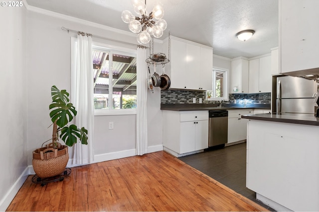 kitchen featuring dark countertops, decorative backsplash, stainless steel appliances, and dark wood-style floors