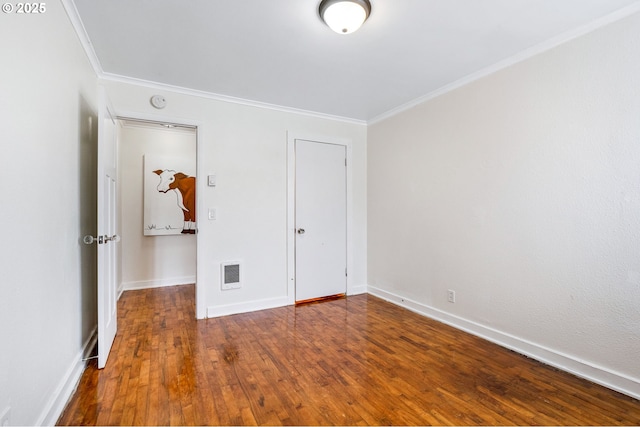 unfurnished bedroom with crown molding, baseboards, wood-type flooring, and visible vents