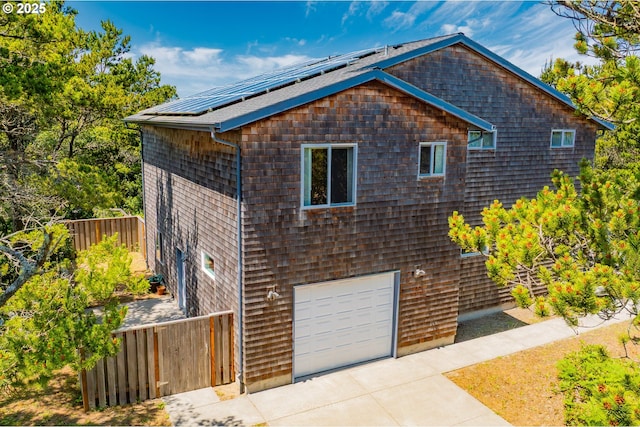 8985 Chinook Ln, Manzanita, OR 97130 - view of property exterior with an attached garage, driveway, and solar panels