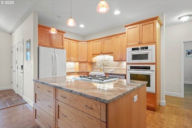 2002 35th St, Washougal, WA 98671 - kitchen with white appliances, baseboards, a center island, decorative backsplash, and light stone countertops