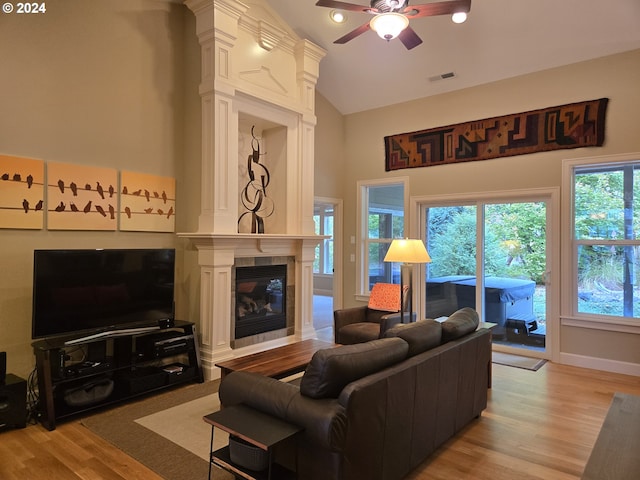899 NW Angel Heights Rd, Stevenson, WA 98648 - living area featuring ceiling fan, light wood finished floors, a tiled fireplace, high vaulted ceiling, and baseboards