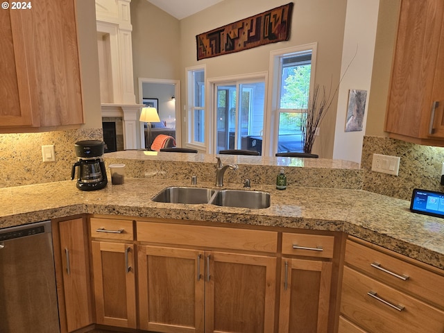 899 NW Angel Heights Rd, Stevenson, WA 98648 - kitchen featuring dishwasher, a sink, decorative backsplash, a tile fireplace, and brown cabinetry