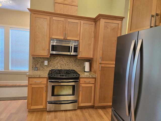 899 NW Angel Heights Rd, Stevenson, WA 98648 - kitchen with appliances with stainless steel finishes, light wood finished floors, light countertops, and decorative backsplash